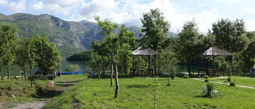 agora camping, agora farmhouse camping, Campingplatz in Albanien, grüne Wiese mit pavillions, mit See und Bergen im Hintergrung