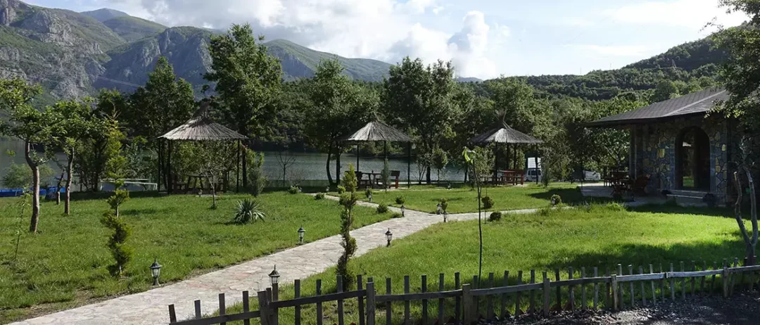 Direkt am Koman See, mit Blick auf die Berge, auf einer großen Wiese und Picknickplätzen. Agora Farmhouse Camping, Agora Camping, Campingplatz in Albanien.